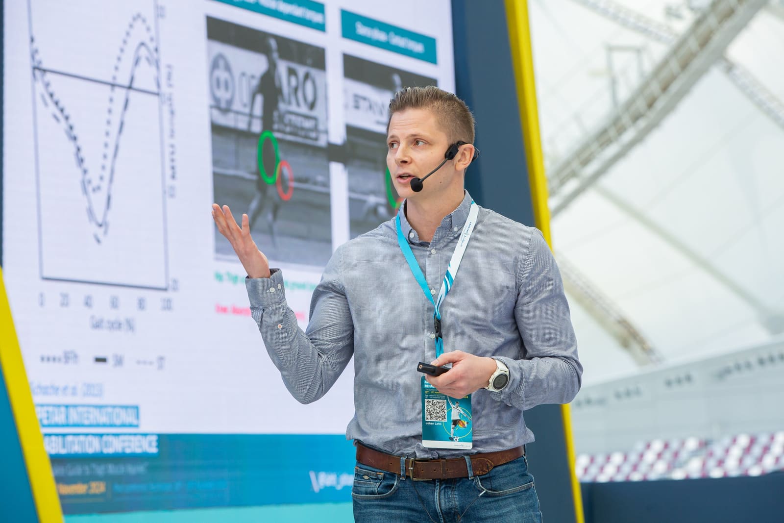 Johan Lahti presenting on stage at the Aspetar International Rehabilitation Conference in Qatar.